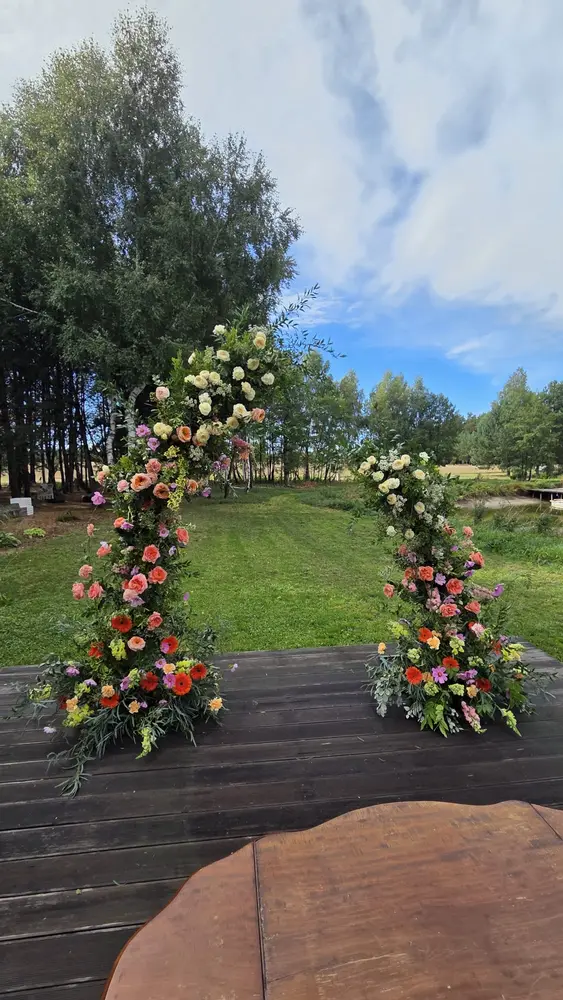 Kwiatowe kolumny ceremonii na drewnianym tarasie