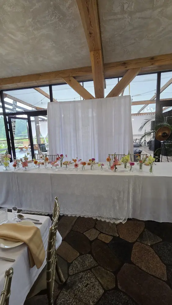 Stół Pary Młodej z rzędem małych wazonów